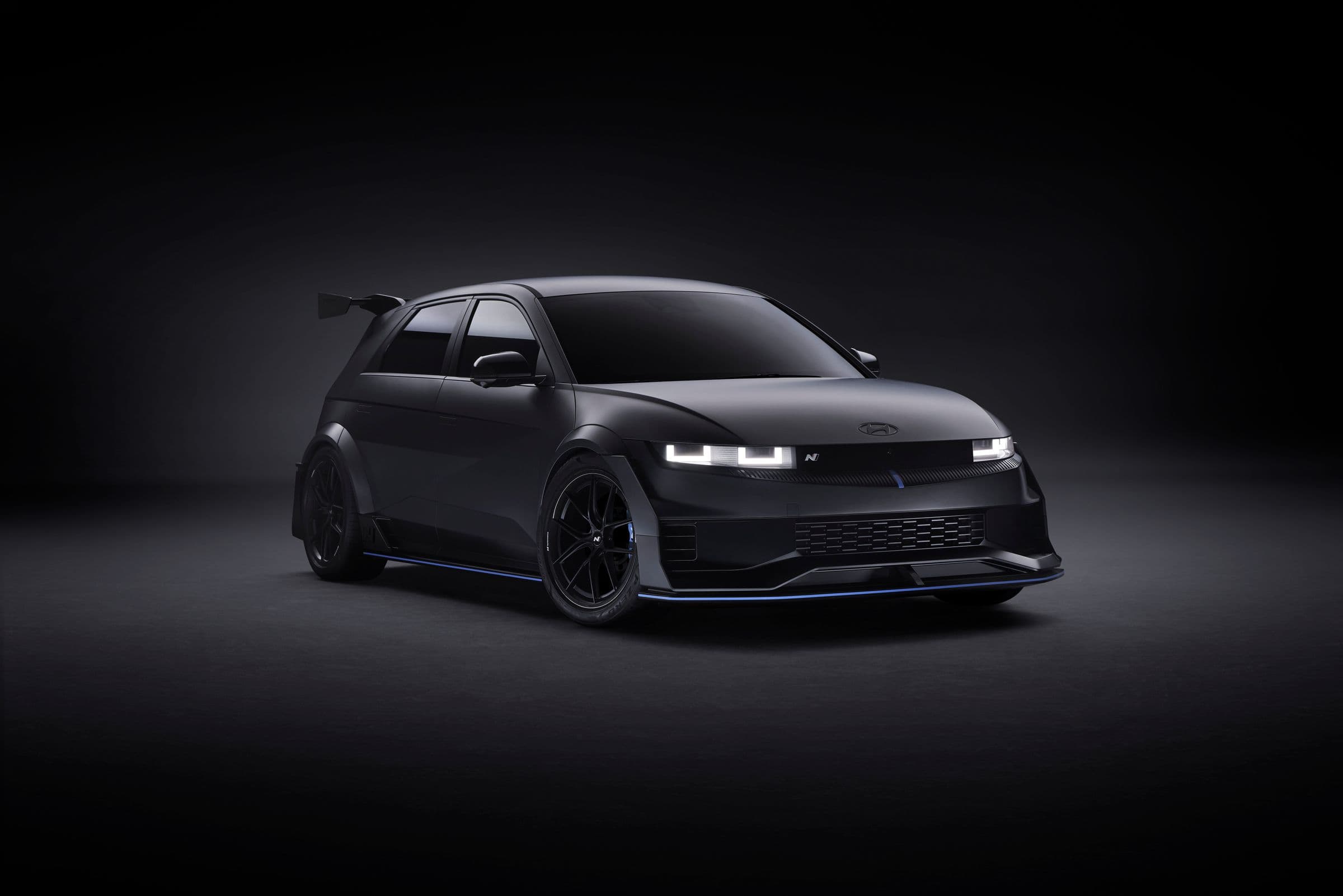 Black performance car illuminated in a dark studio